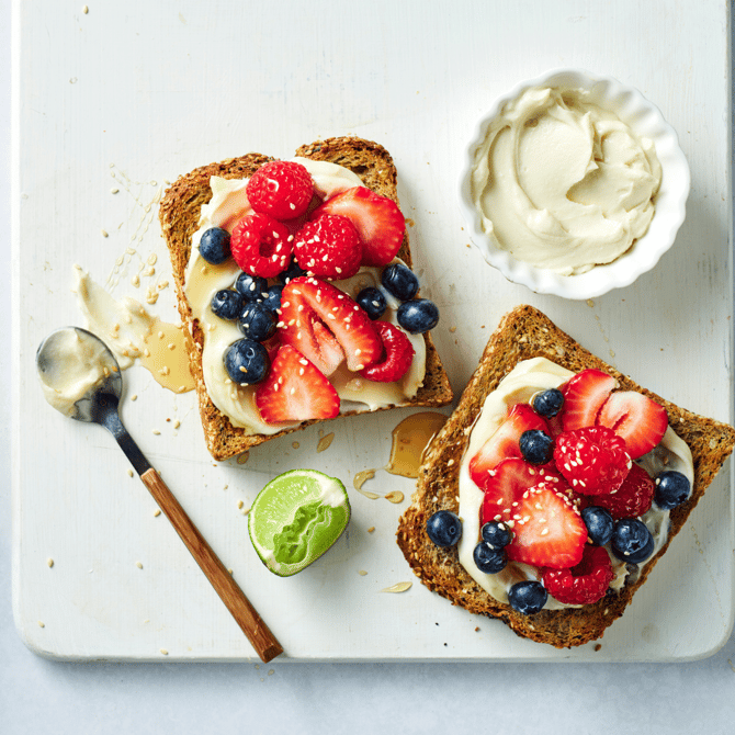 Two pieces of toast topped with ricotta and fresh berries