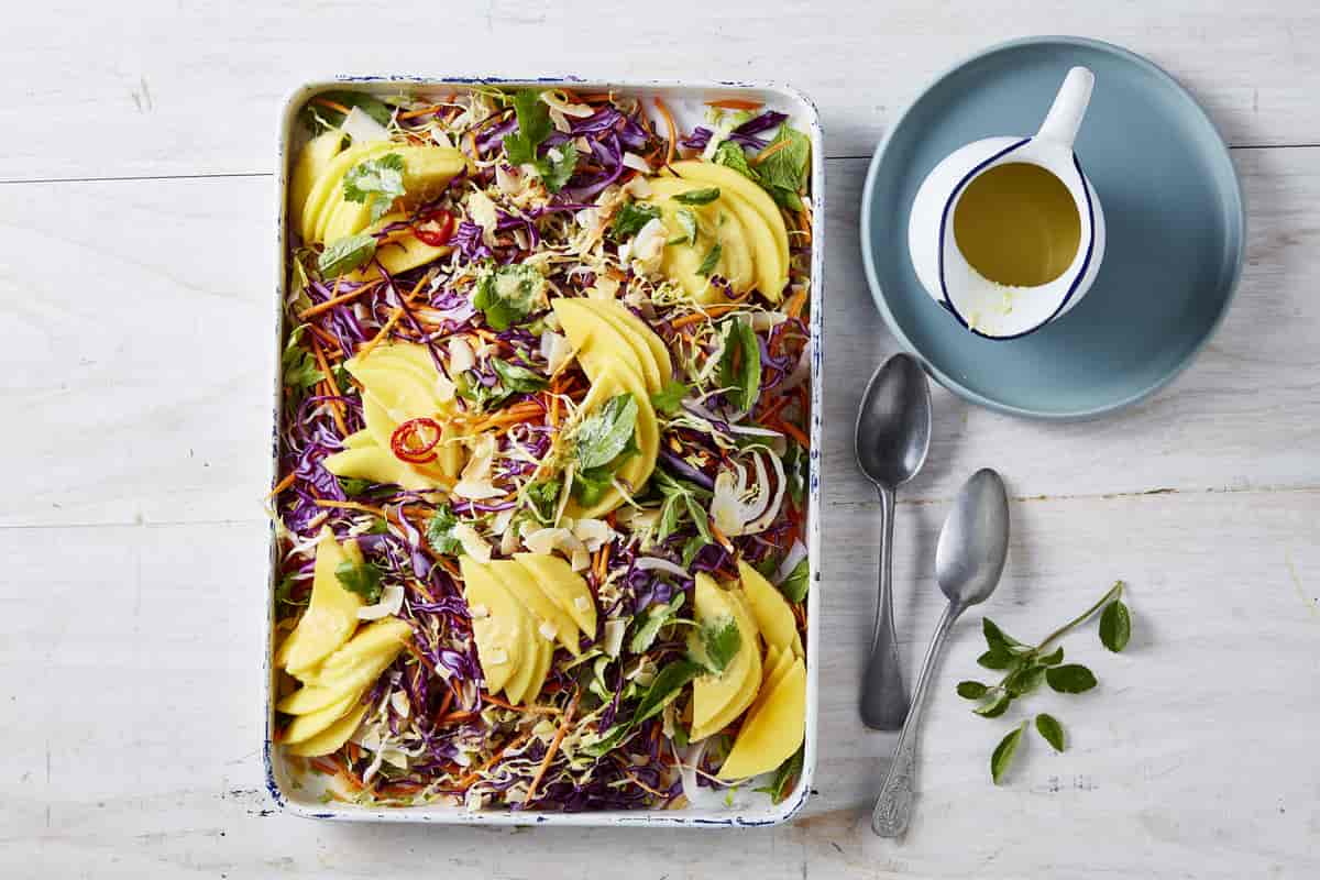 Thai Style Mango Slaw in a rectangle dish with two forks on the side.