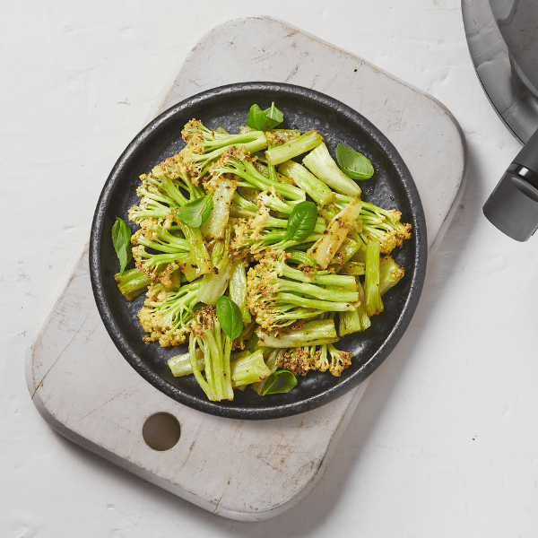 Airfried cauli-blossom in an oven dish with basil leaves.