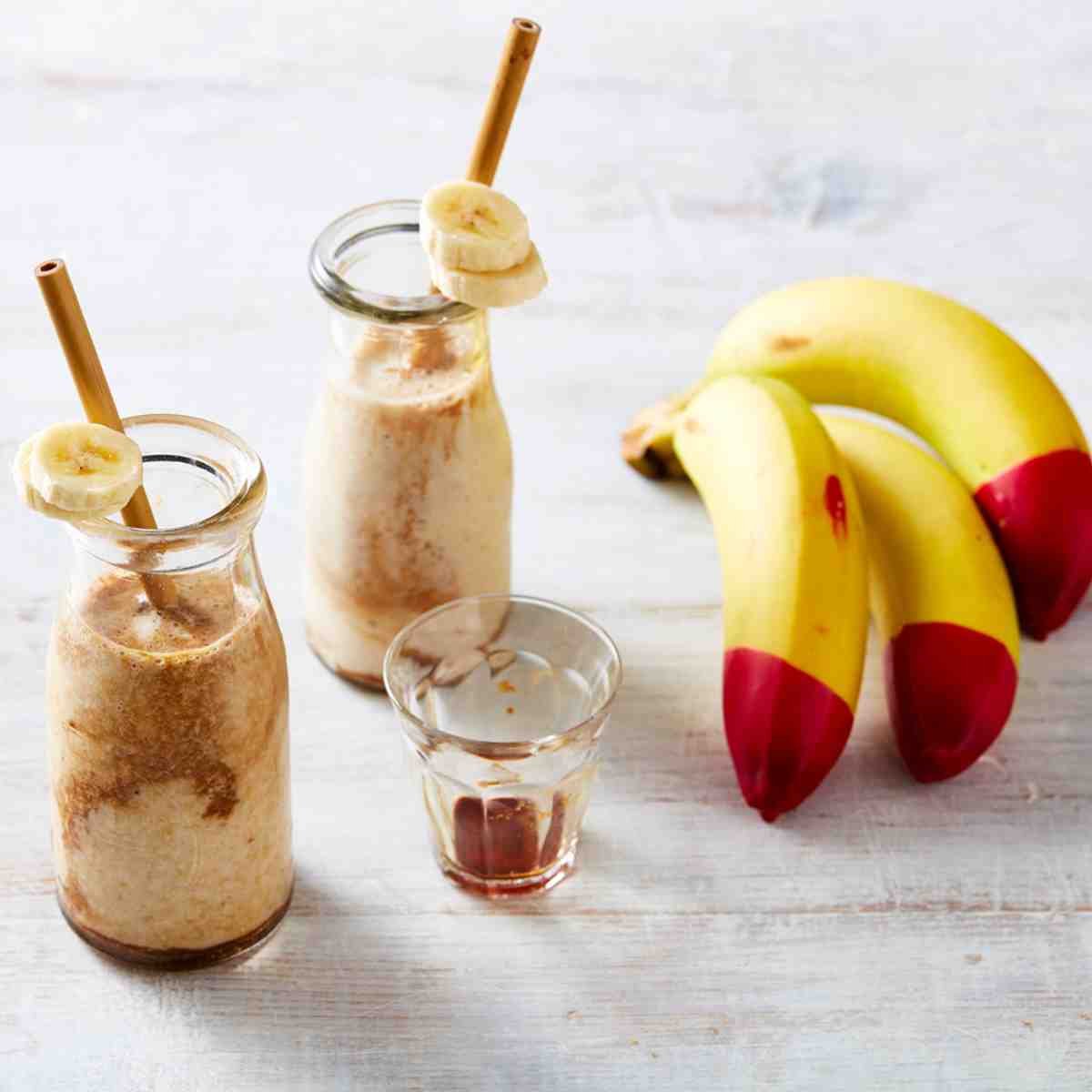 Espresso Banana Breakfast Shake in milk bottles, with bananas placed next to the bottles.