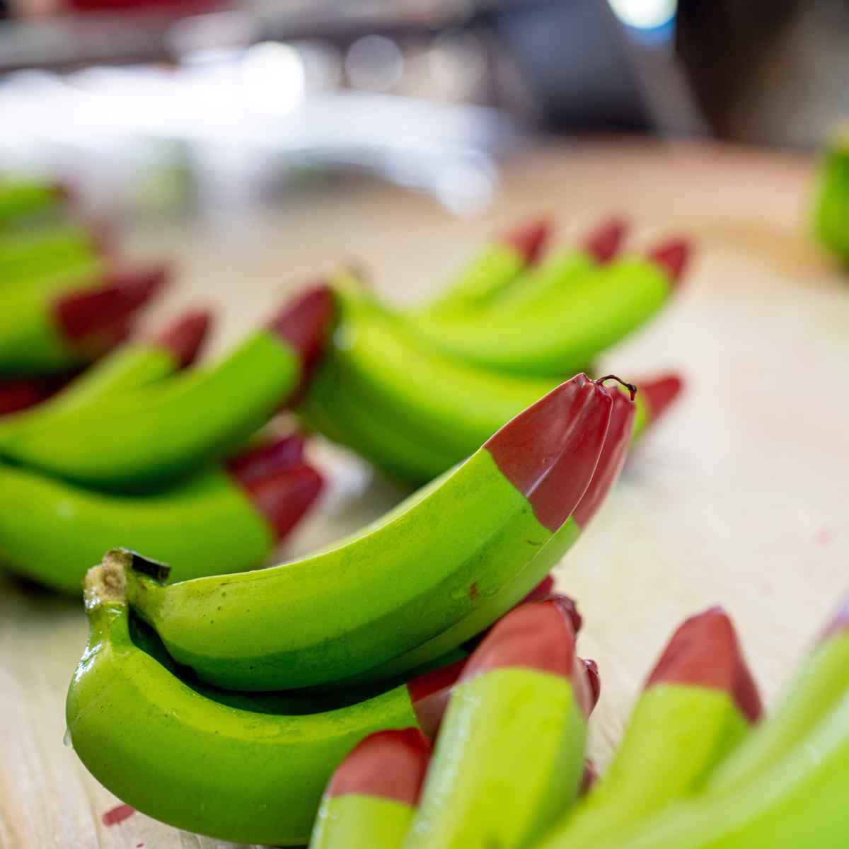 Bunches of bananas with tips dipped in red wax.