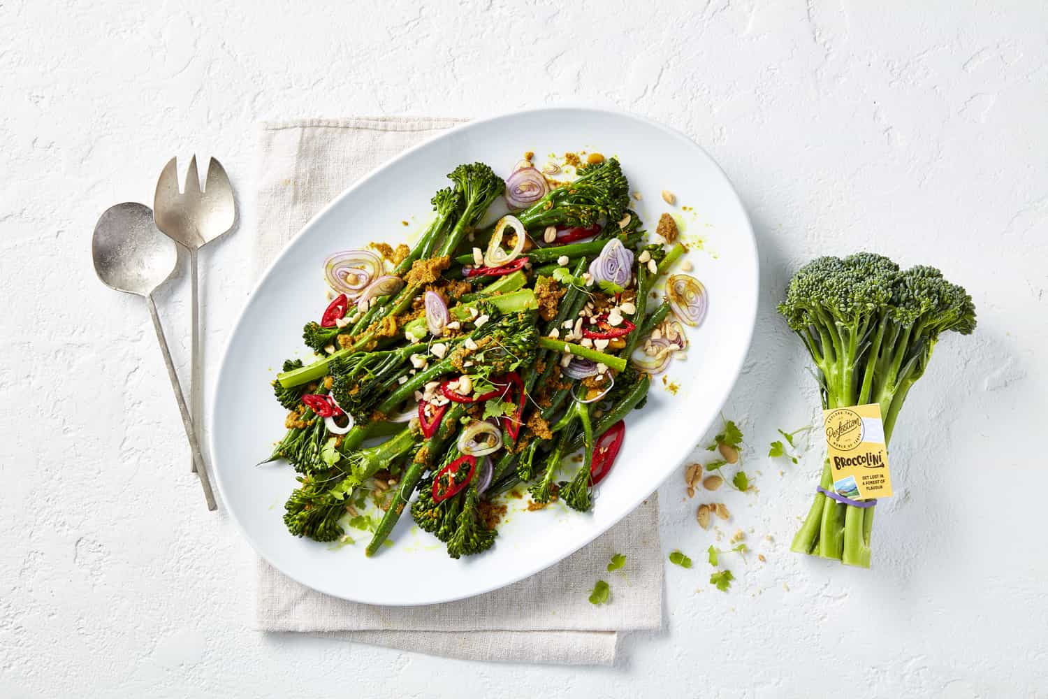 A white platter with Indian spiced broccolini in it.