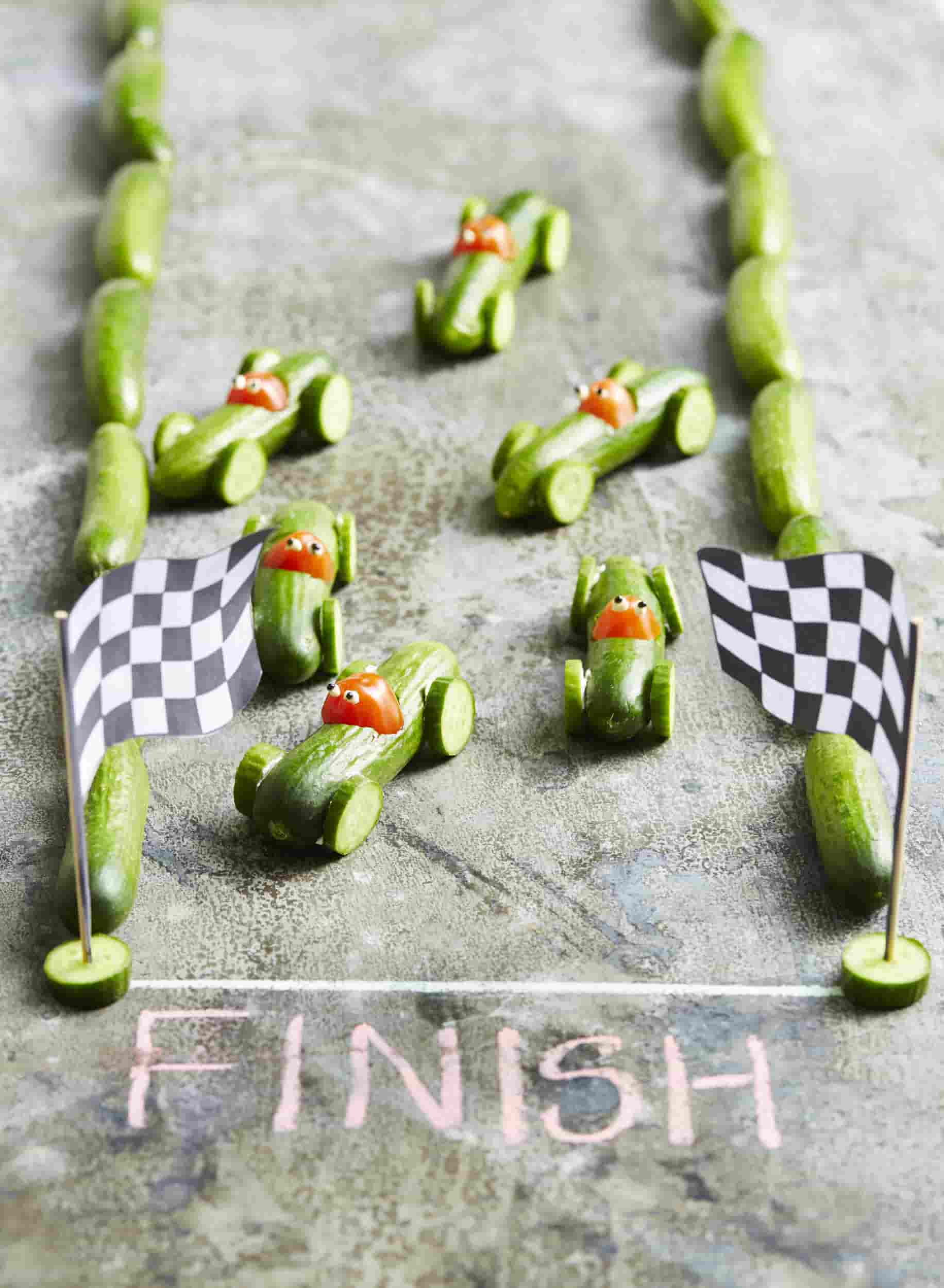 Edible racing cars made out of Qukes cucumbers and medley tomatoes.
