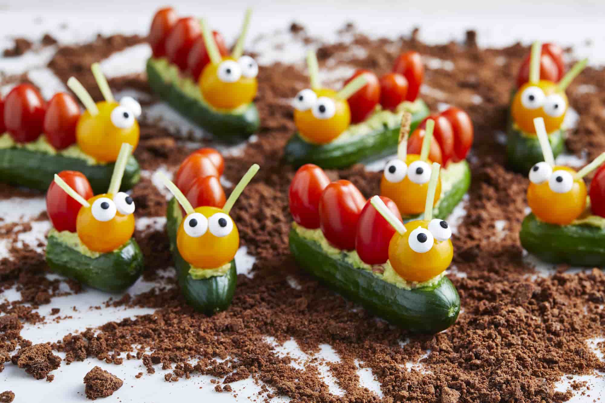 A bunch of edible caterpillars made using baby cucumbers and medley tomatoes.  