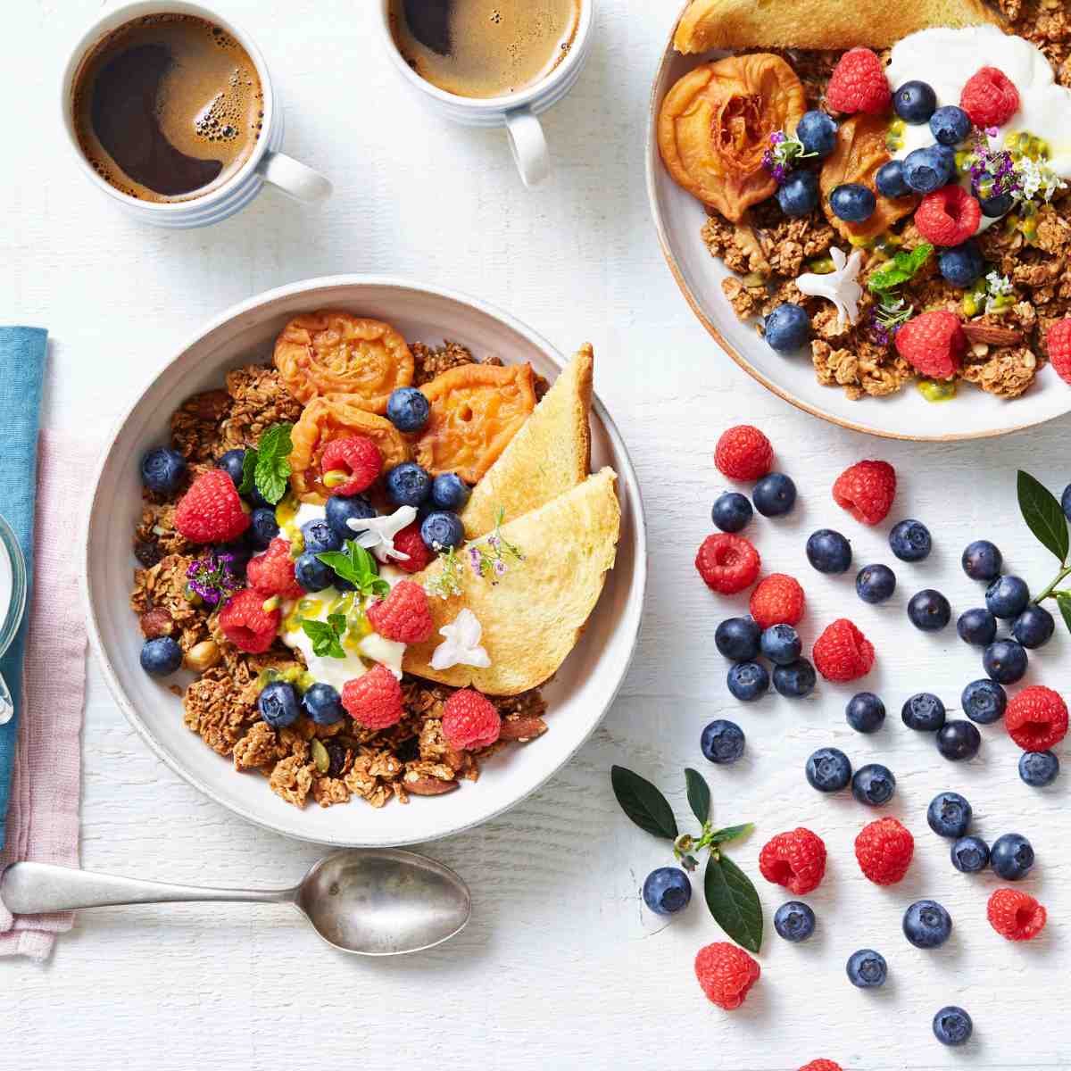 A bowl of oatmeal topped with granola, toast and berries.