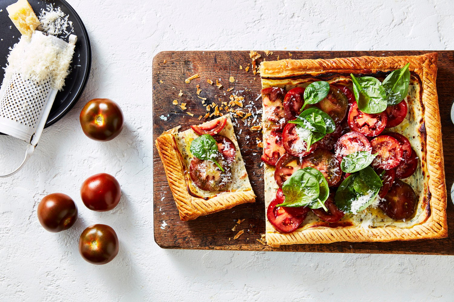 Puff pastry tart topped with sliced Kumato tomatoes, basil and cheese.