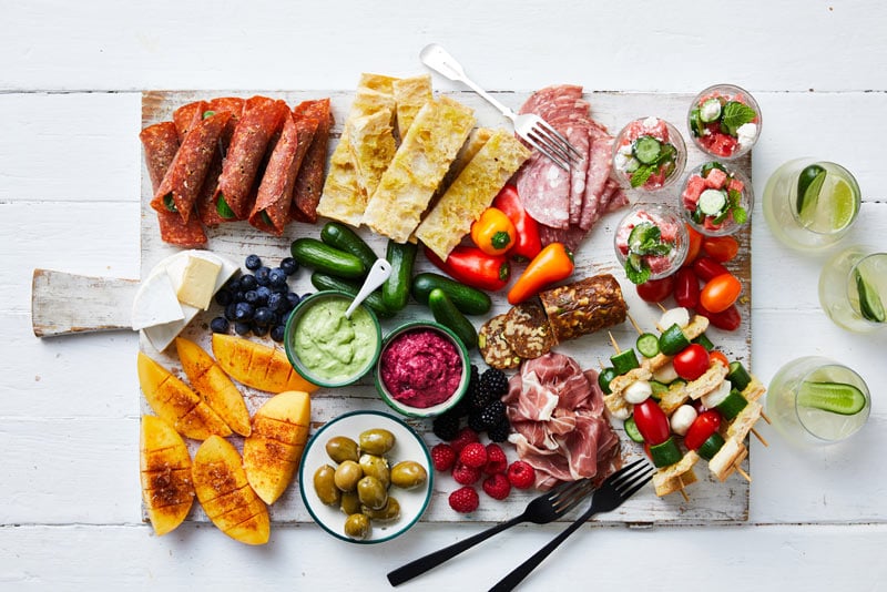 Grazing platter with fruits, vegetables, olives and dips.