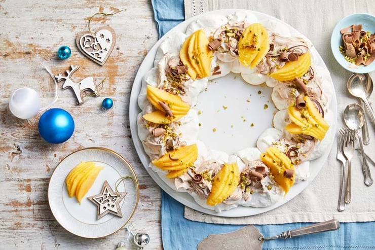 Pavlova wreath topped with Calypso mangoes, and hazelnut spread.