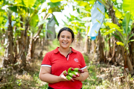 Alana holding Ecoganic Bananas amoungst the plantation.