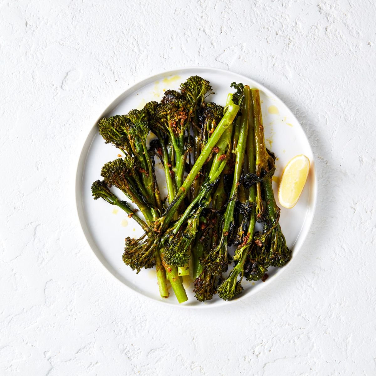 Roasted broccolini in a white plate.