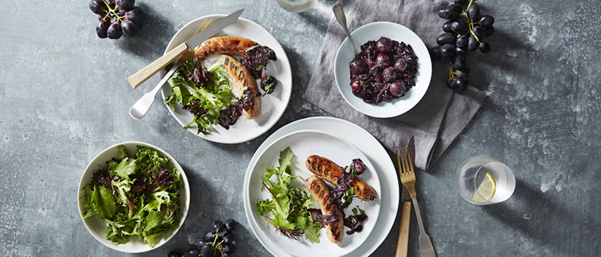 BBQ Italian Sausages with Midnight Beauty® Grapes and Caramelised Onions Recipe